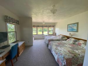 um quarto de hotel com duas camas e uma televisão em Peters Sunset Beach Resort and Golf em Glenwood