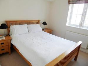 a bedroom with a large white bed and two windows at Basingstoke Apartments - Westlands House, City Centre, Home-From-Home in Basingstoke