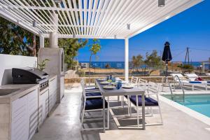 a patio with a table and a grill and a pool at Constantinos Villa, Sublime Island Εscape, By ThinkVilla in Panormos Rethymno