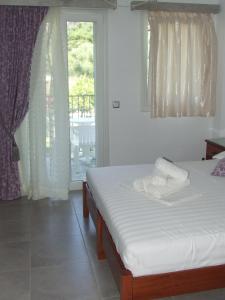 a bedroom with two beds and a window at Perivoli Tessas' in Parga