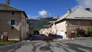 an empty street in a town with buildings and a bench at Le Galet "Chez Jacquie et Fifi" in Mont-Dauphin