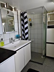 a white bathroom with a sink and a mirror at 1B, Stuga m havsutsikt & 50m till strand in Byxelkrok