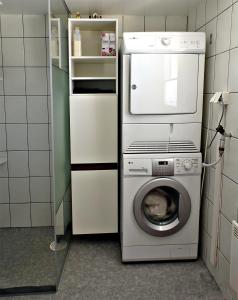 a kitchen with a washing machine and a microwave at 1B, Stuga m havsutsikt & 50m till strand in Byxelkrok