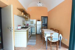 una cucina con tavolo, sedie e frigorifero di Casa Annalí - House and garden by the Amalfi Coast a Maiori