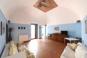 un soggiorno con pareti blu e divano di Casa Annalí - House and garden by the Amalfi Coast a Maiori