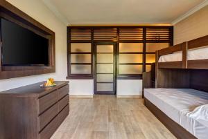 a bedroom with a bed and a flat screen tv at Royalton Splash Punta Cana, An Autograph Collection All-Inclusive Resort & Casino in Punta Cana