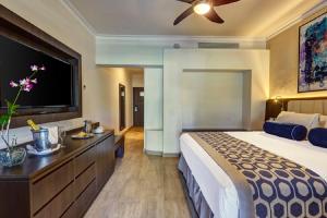a bedroom with a large bed and a flat screen tv at Royalton Splash Punta Cana, An Autograph Collection All-Inclusive Resort & Casino in Punta Cana