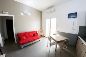 a living room with a red couch and a table at Villa Giambona in Isola delle Femmine