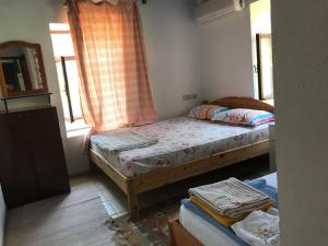 a small bedroom with a bed and a window at Likya Pansiyon in Kaleucagız