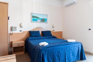 a bedroom with a blue bed with towels on it at Hotel Mauritius Sentirsi come a Casa in Riccione