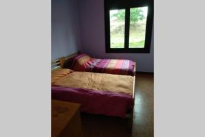 a small bedroom with a bed and a window at Vidal Rural in Aviá