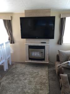 a living room with a flat screen tv above a fireplace at G17 The Chase , Ingoldmells, Skegness in Ingoldmells