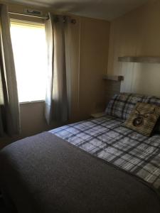 a small bedroom with a bed and a window at G17 The Chase , Ingoldmells, Skegness in Ingoldmells