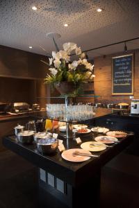 a table topped with plates of food and a vase filled with flowers at Royal Boutique Savassi Hotel in Belo Horizonte