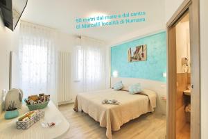 um quarto com uma cama com uma parede azul em Affittacamere I Principi del Conero CIR 00041 em Numana
