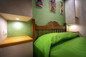 a green bedroom with a bed with a wooden head board at Green house in Orvieto