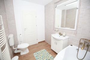 a white bathroom with a toilet and a sink at Casa din Deal in Corbu +37 photos