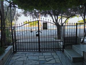 Una puerta de hierro negra con un cartel. en Villa Tasos, en Nea Peramos