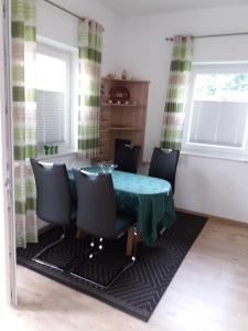 a dining room with a green table and chairs at Ferienhaus Am Barenberg in Thülsfeld