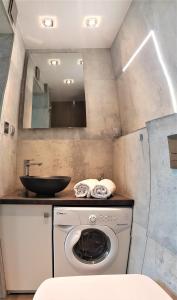 a bathroom with a washing machine and a sink at Planet Hostel in Warsaw