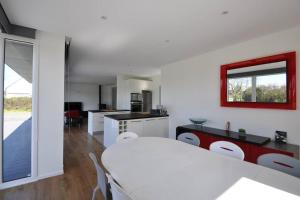 a kitchen and living room with a table and chairs at Villa de l'albatros Sables d'or in Plurien