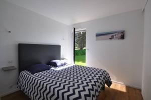 Un dormitorio con una cama en blanco y negro y una ventana en Villa de l'albatros Sables d'or en Plurien