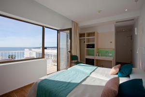 Schlafzimmer mit einem Bett und Blick auf einen Balkon in der Unterkunft BLUESEA Anba Romaní in Cala Millor