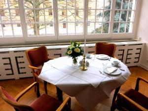a table with a vase of flowers on top of it at Gästehaus Leipzig in Leipzig