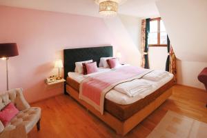 ヴァイセンキルヒェン・イン・デア・ヴァッハウにあるRenaissancehotel Raffelsberger Hof B&Bのベッドルーム1室(ピンクの枕が付いた大型ベッド1台付)