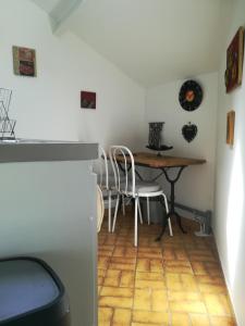 a dining room with a table and white chairs at Cath's place in Toulon