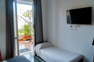 Zimmer mit einem Stuhl und einem Flachbild-TV in der Unterkunft Tui Beds in Arenzano