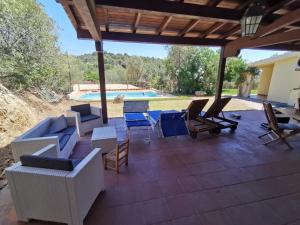 a patio with chairs and a table and a pool at villa rubia in Villasimius