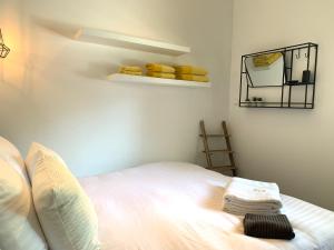 um quarto com uma cama e uma prateleira com toalhas em Finch guesthouse em Zandvoort