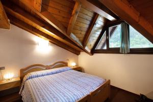 sypialnia z łóżkiem i dużym oknem w obiekcie Albergo Moleta w mieście Spiazzo