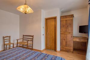 - une chambre avec un lit, une table et des chaises dans l'établissement Albergo Moleta, à Spiazzo