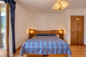 um quarto com uma cama com um edredão azul em Albergo Moleta em Spiazzo