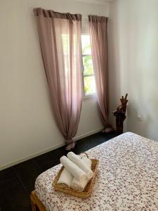 a bedroom with a bed with a basket of towels at Workation - La Casita de Elsi y Fran in Costa Calma