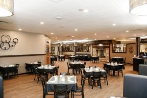 une salle à manger avec des tables et des chaises noires dans l'établissement Billings Hotel & Convention Center, à Billings