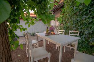 a white table and chairs in a garden at Apartment Ana - Karst Cycling Paradise in Dutovlje