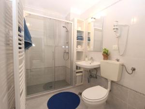 ein Bad mit einer Dusche, einem WC und einem Waschbecken in der Unterkunft Apartments Mareblu in Rabac