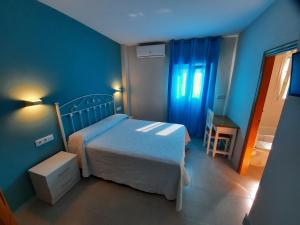 sypialnia z łóżkiem i niebieską ścianą w obiekcie Hostal Costa Rica w mieście San José