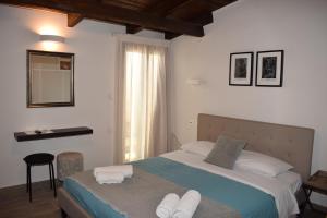 a bedroom with a bed with towels on it at Loggia Traditional Suites in Rethymno Town