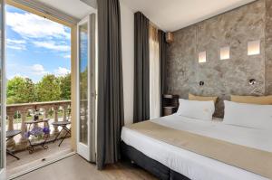 a bedroom with a large bed and a balcony at Hotel Ancora in Verbania
