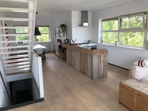a living room with a staircase and a kitchen at The Boathouse with boat in Aalsmeer
