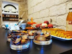 a table topped with glasses of fruit and a plate of food at la chambre des petits papes, intra muros in Avignon