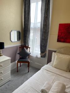 a bedroom with a bed and a chair and a window at The Mountview in Scarborough