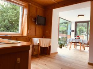 een keuken en eetkamer met een tafel en een televisie bij Haus Tannenburg in Funes