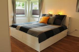 a large bed in a room with two windows at Ferienhaus Pape Gleidorf in Schmallenberg