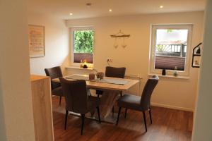 een eetkamer met een tafel en stoelen en 2 ramen bij Ferienhaus Pape Gleidorf in Schmallenberg