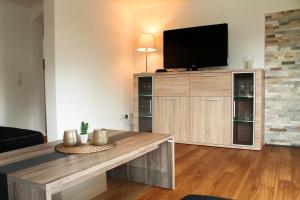 a living room with a large entertainment center with a flat screen tv at Ferienhaus Pape Gleidorf in Schmallenberg